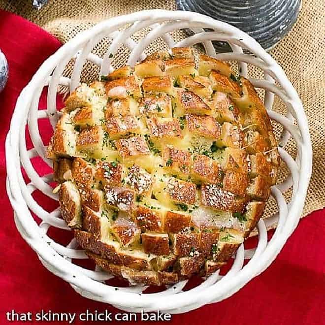 Cheesy Garlic Bread - A crosshatch cut loaf full of melty cheese and garlic! Overhead view of Cheesy Garlic Bread in a ceramic basket.