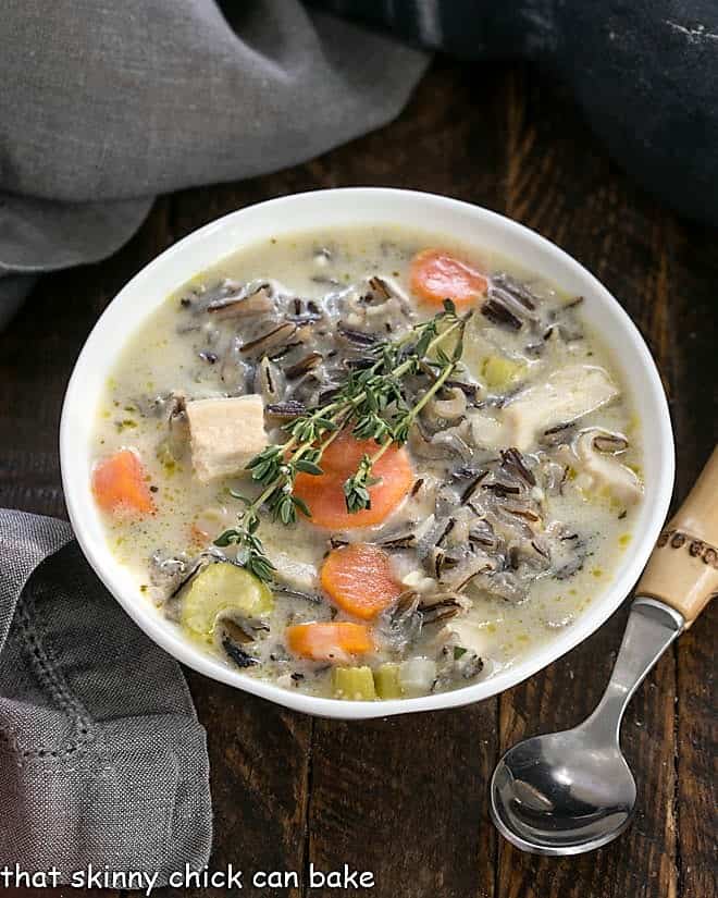 Chicken with Wild Rice Soup is a velvety, hot, comfort food for a chilly day. I dug out my mom's Wild Rice Soup recipe and added chicken and some extra vegetables. This warm, comforting meal is easy to make! Overhead view of a bowl of wild rice soup with a bamboo handle spoon.