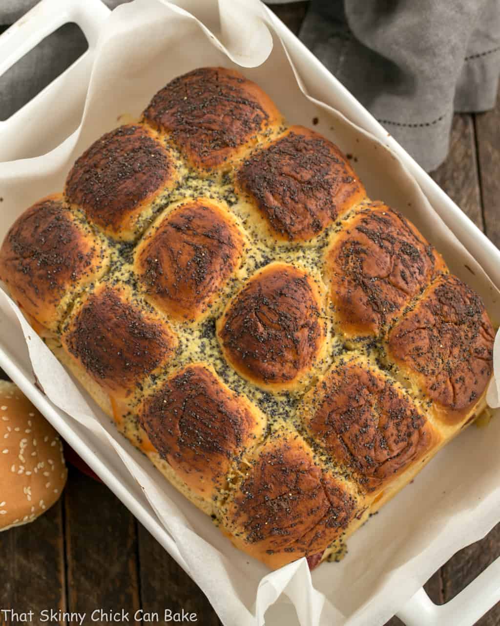 Corned Beef Sliders - All the fabulous flavors of a Reuben Sandwich in a slider! Corned Beef Sliders in a white ceramic baking dish viewed from above.