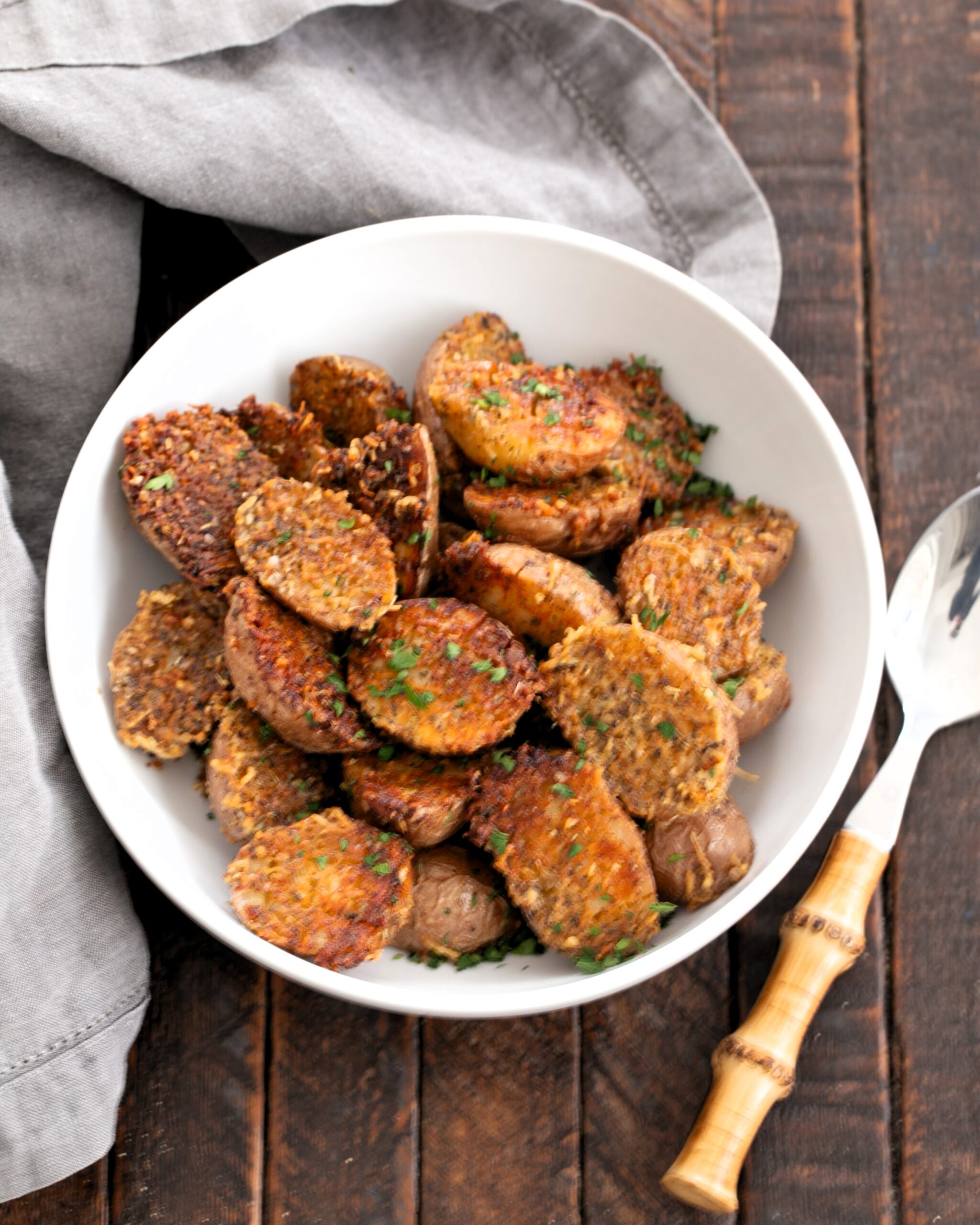 Roasted potatoes in a white serving bowl.