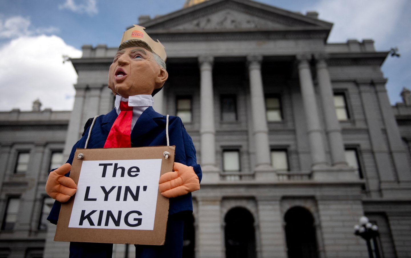 A puppet in the likeness of US President Donald Trump holding a sign reading “The Lying King” is held up held up in front of the Colorado State Capital during the “No Kings” national rally in Denver, Colorado.