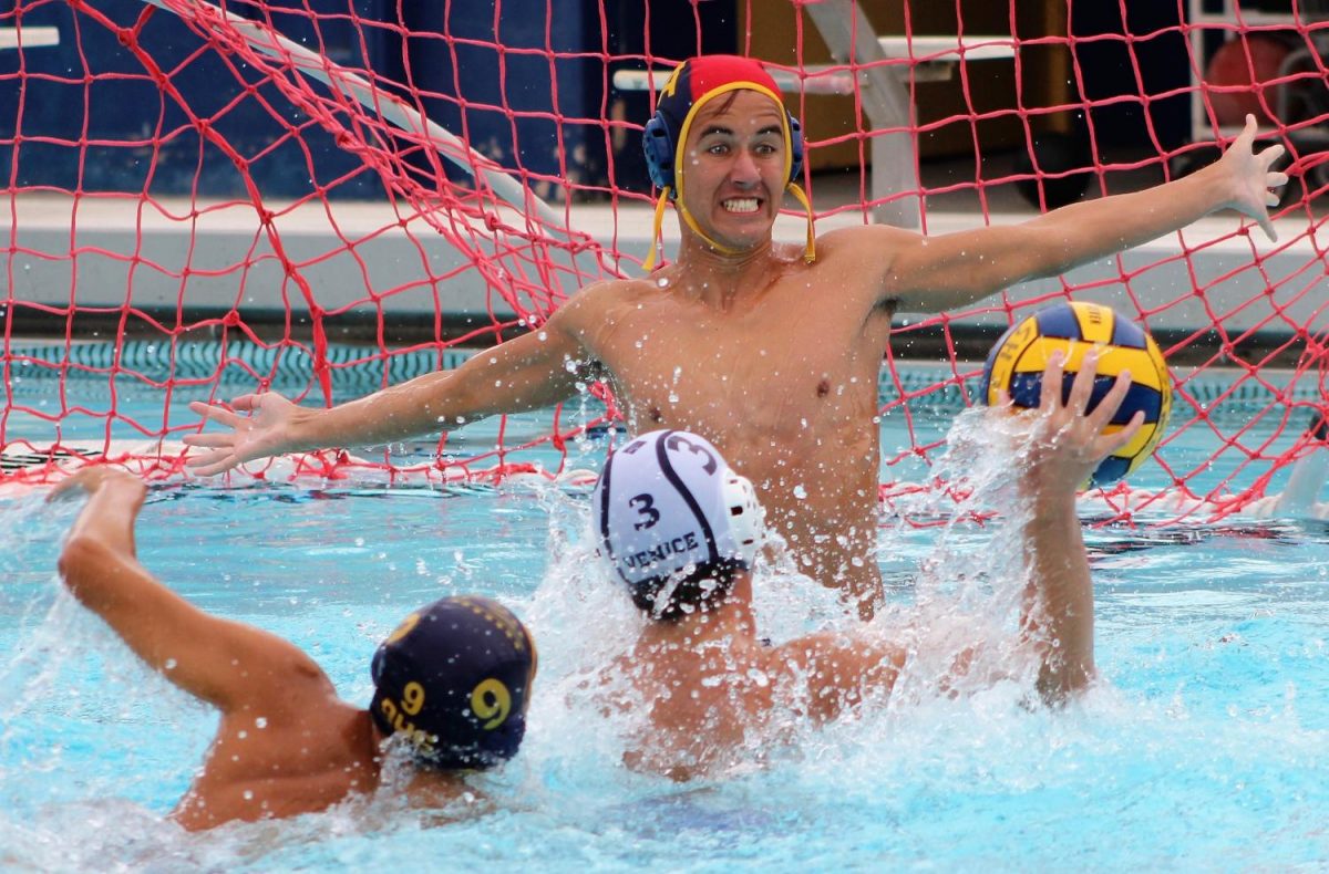 Varsity water polo goalie attempts to block a shot The Pearl Post