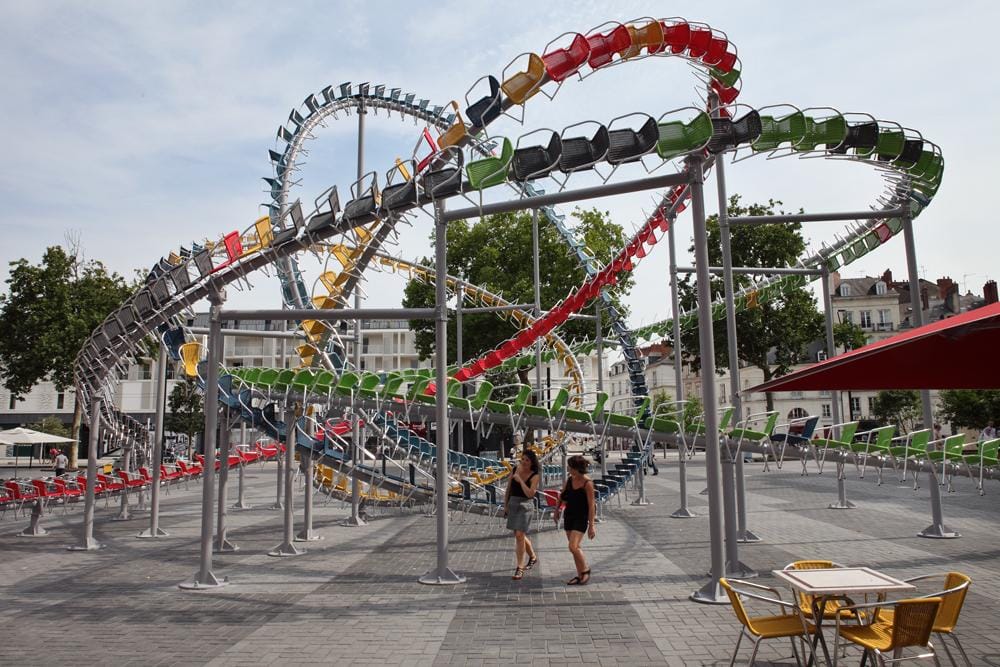 Hundreds of Colorful Café Chairs Take the Form of a Winding Roller Coaster in the Middle of a