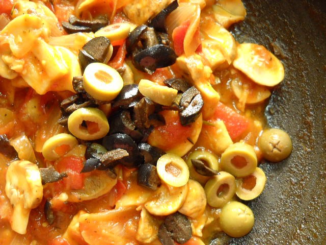 adding-chopped-olives sliced olives added to the tomato mushroom sauce.