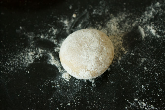fried-modak9 flattened round of dough sprinkled with flour on a flour dusted surface