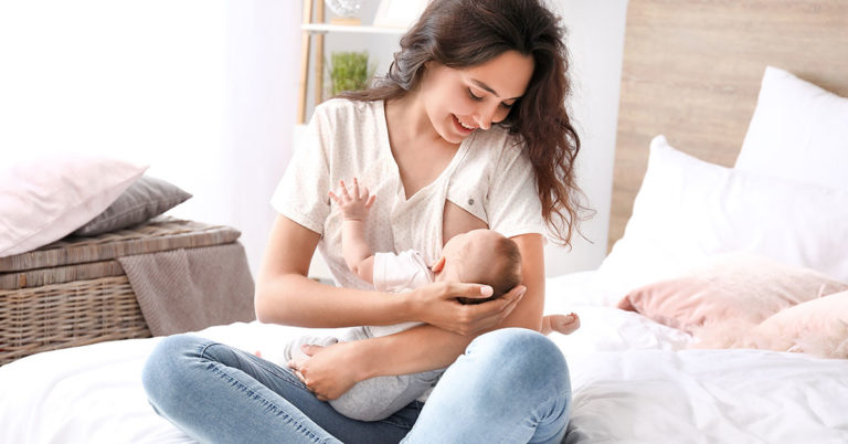 Young woman breastfeeding her baby at home Wake Forest Pediatrics