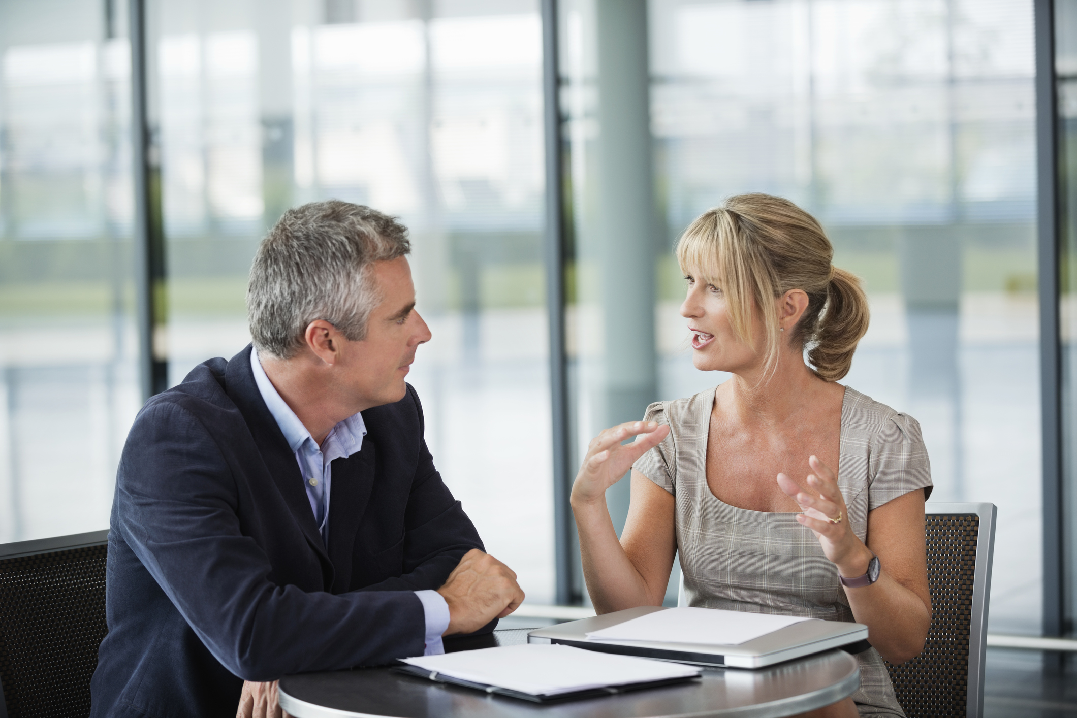 Two business people sitting, having a conversation – WorkWare