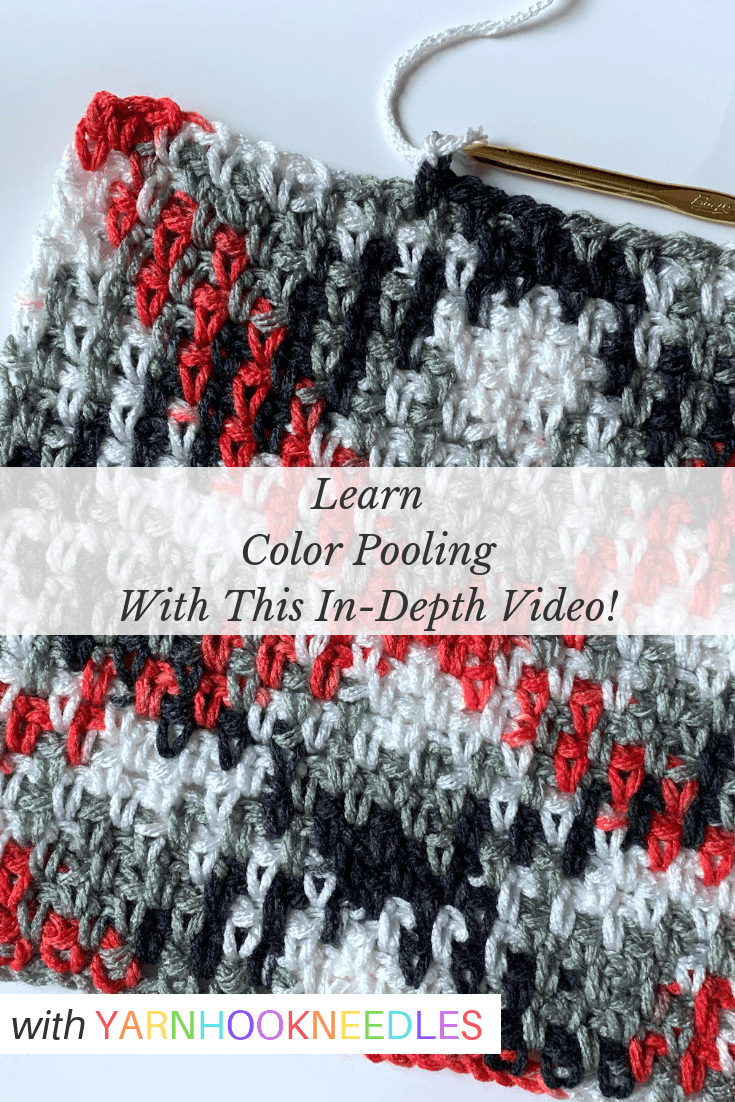 a black, white, and red yarn in a crochet color pooling yarn with golden crochet hook