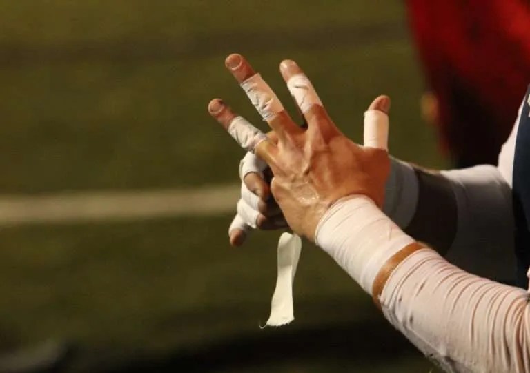 A soccer goalie’s hands are seen wrapped in white athletic tape, as are his wrists prior to a