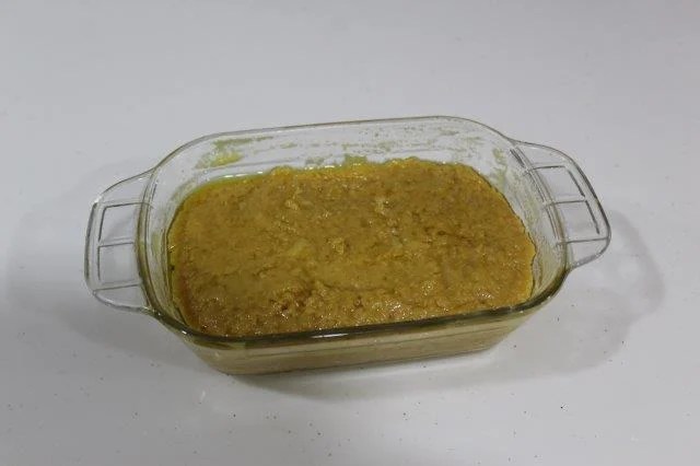 spoon milk cake mixture in mould and flatten the top