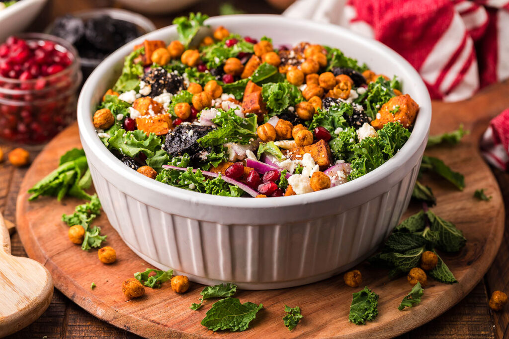 A sweet potato kale salad in a large white bowl.